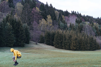 Side view of man jumping on grassy field