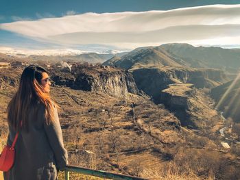 Midsection of woman standing on mountain against sky