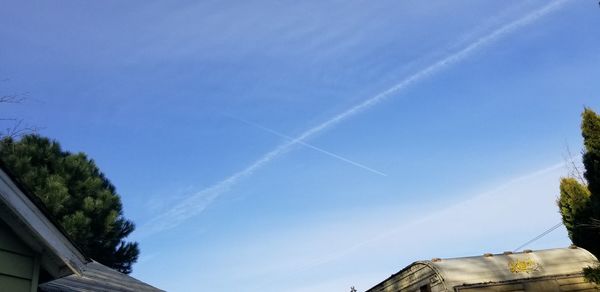 Low angle view of vapor trail against blue sky