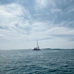 Sailboat sailing on sea against sky