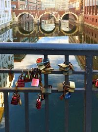 Padlocks on bridge railing over river