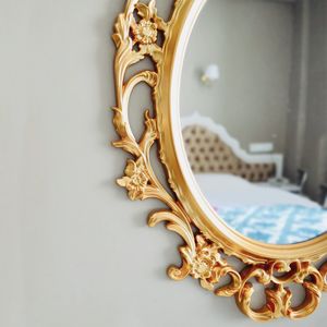 Reflection of bed in mirror mounted on wall at hotel