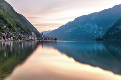 Scenic view of lake and mountains against sky during sunset