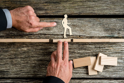 High angle view of person hand holding wooden table