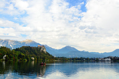 Scenic view of lake by mountains against sky