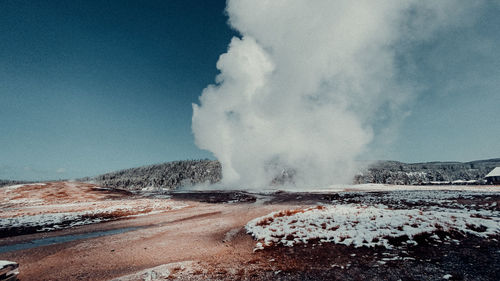 Panoramic view of waves breaking on land against sky