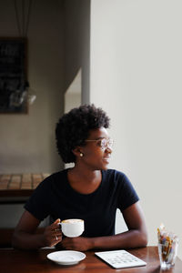 Young woman with coffee cup on table