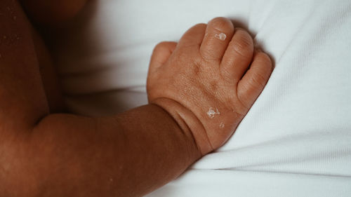 Close-up of person hand on bed