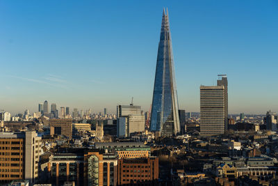 Modern buildings in city against clear sky