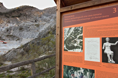 Information sign on mountain against sky