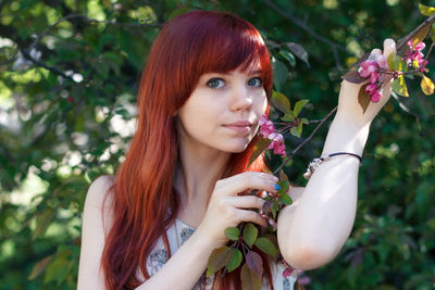 Portrait of young woman with red flowers