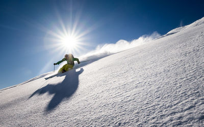 Man skiing on mountain against sky