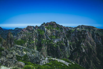 Scenic view of rocky mountains against blue sky