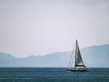 Sailboat sailing on sea against clear sky