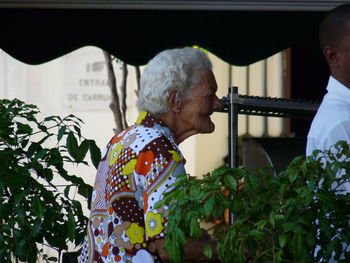 Close-up of man and woman standing against wall