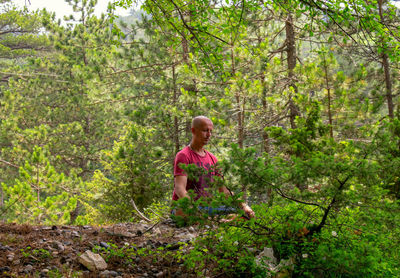 Full length of man meditating in forest