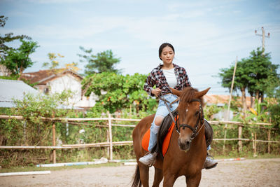 Portrait of woman riding horse in park