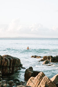 Scenic view of rocks in sea against sky