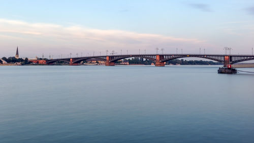 Bridge over river against cloudy sky