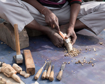 Low section of man carving wood