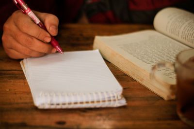 Midsection of person reading book on table
