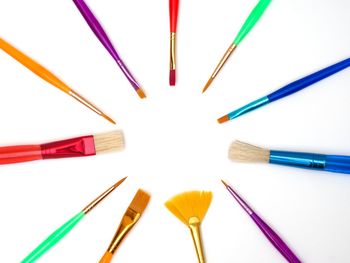 Close-up of colored pencils over white background