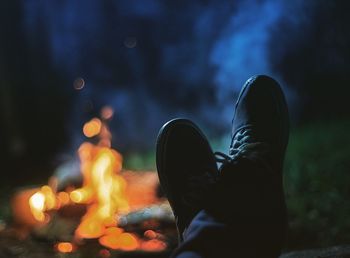 Low section of person against illuminated fire