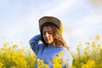 Young woman wearing hat on field against sky