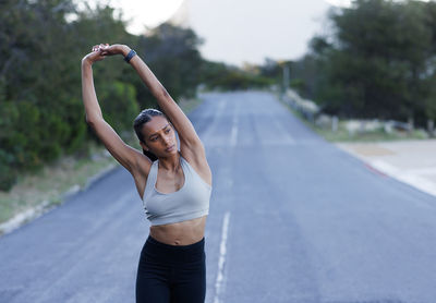 Rear view of woman exercising on road