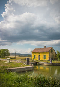 Houses by lake against sky