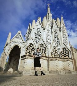 Full length of woman standing outside building against sky