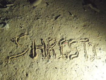 Close-up of text on sand