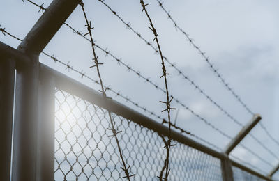 Low angle view of chainlink fence against sky