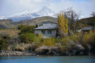 House by lake against mountains