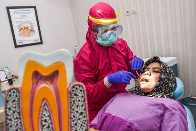 Dentist using mask and protection wear during covid-19 pandemic