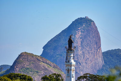 Statue on mountain against clear sky