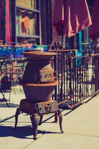 Old rusty container on sidewalk during sunny day