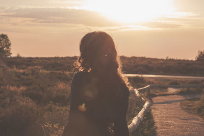 Rear view of woman looking at sunset