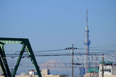 Low angle view of crane against clear blue sky