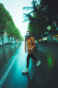 Woman standing by tree in city during winter