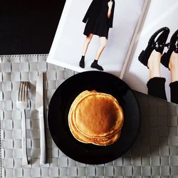 Directly above view of fresh pancakes with magazine on table