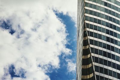 Low angle view of modern building against cloudy sky