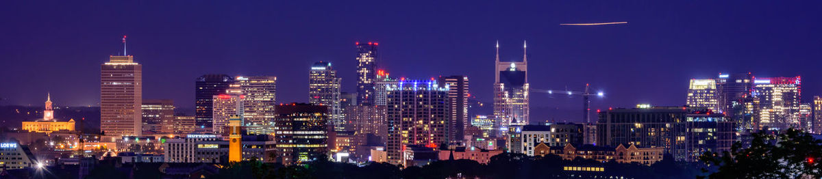 Panoramic view of illuminated buildings against sky at night