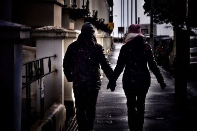 Rear view of silhouette people walking on street in winter