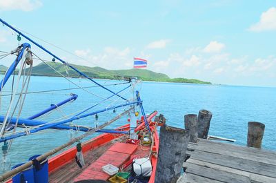 Boat moored at pier against sky