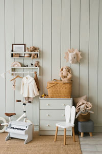 Scandinavian-style children's room, chest of drawers, bicycle, toys, piano toy, armchair and clothes