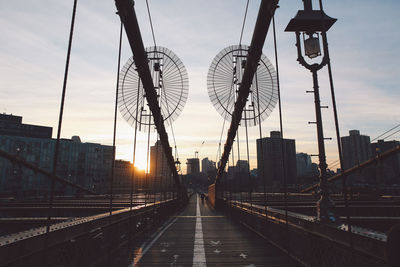 Brooklyn bridge against cloudy sky during sunset