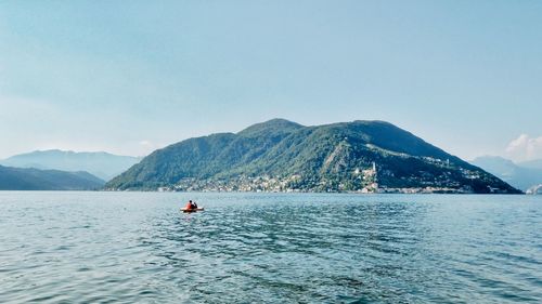 Scenic view of sea by mountains against sky