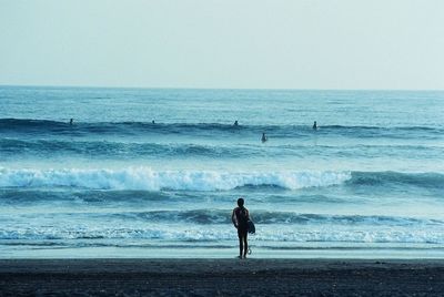 Rear view of scuba diver standing on beach