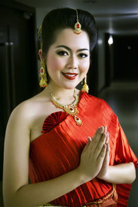 Portrait of beautiful woman wearing sari and jewelry standing in prayer position